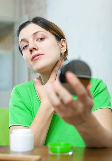 woman looks on her skin