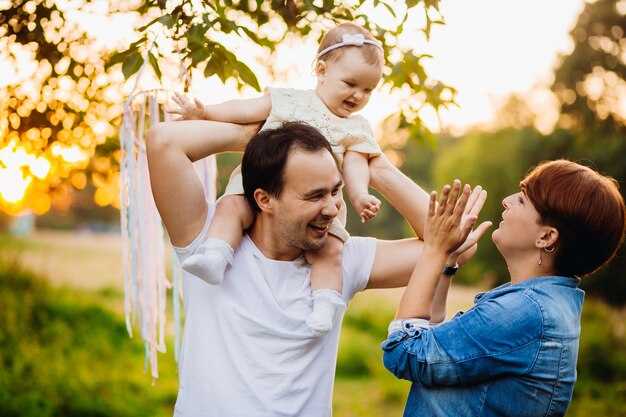 Woman looks at little girl on man's neck 