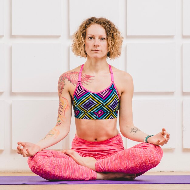 Woman in lotus pose looking at camera