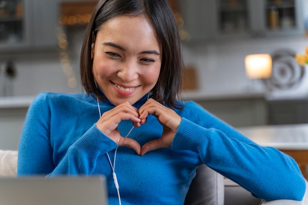 Foto gratuita donna innamorata del computer portatile a casa con un colpo medio