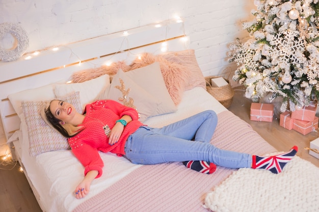 Free photo woman lying on bed at christmas