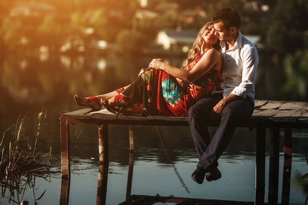 Woman lying on her boyfriend in a wooden harbor