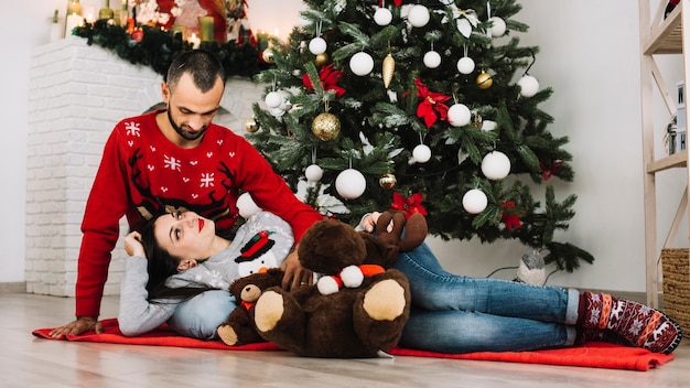 Foto gratuita donna che si trova sull'uomo vicino a giocattoli morbidi