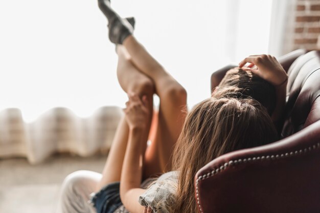 Woman lying on man's lap sitting in chair loving each other