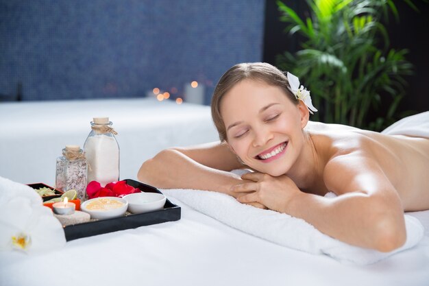 Woman lying in the massage room with a tray of aromas