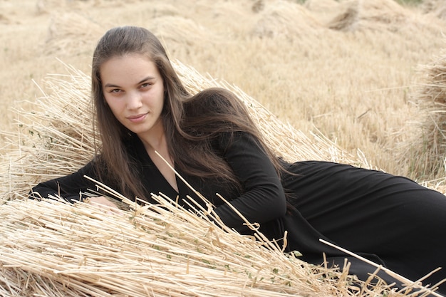 Free photo woman lying on a pile of straw