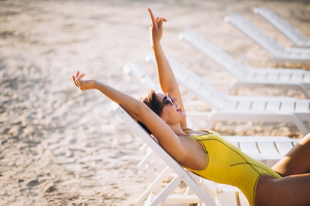 Woman lying on pool bed by the sea