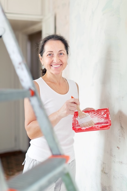 Женщина делает ремонт дома