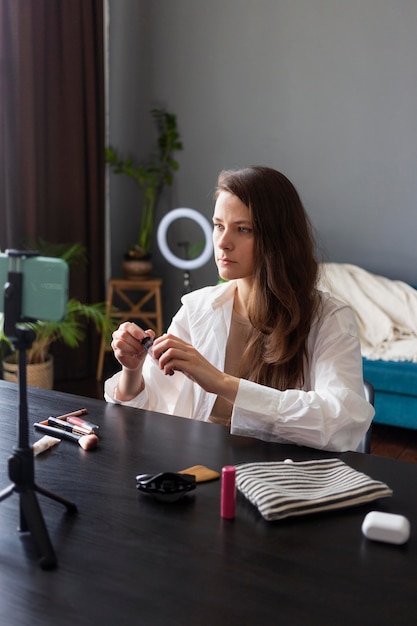 Foto gratuita donna che fa un vlog di bellezza con il suo smartphone