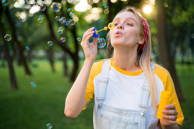 Woman making bubbles outdoors