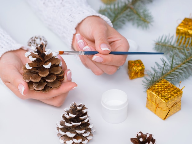 松ぼっくりでクリスマスの飾りを作る女性