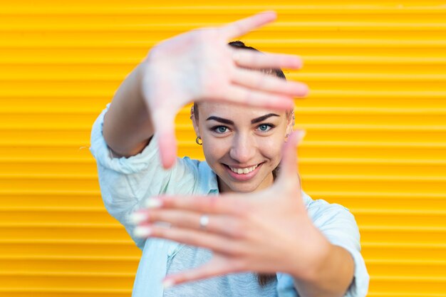 Free photo woman making a frame with her hands while looking at the camera