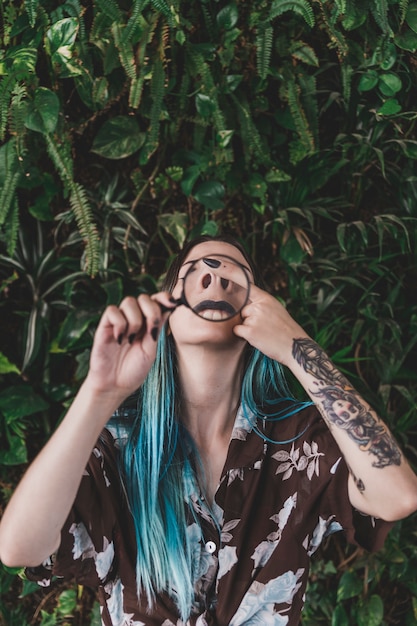 Woman making funny face through a magnifying glass