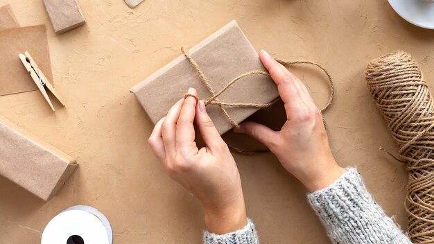 Free photo woman making a gift box, hand made things and materials composition. top view