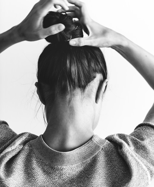 Foto gratuita donna che fa ciambella per capelli
