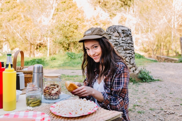 Woman making hot dogs in nature