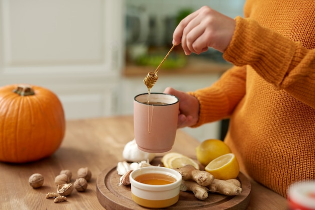 蜂蜜で熱いお茶を作る女性