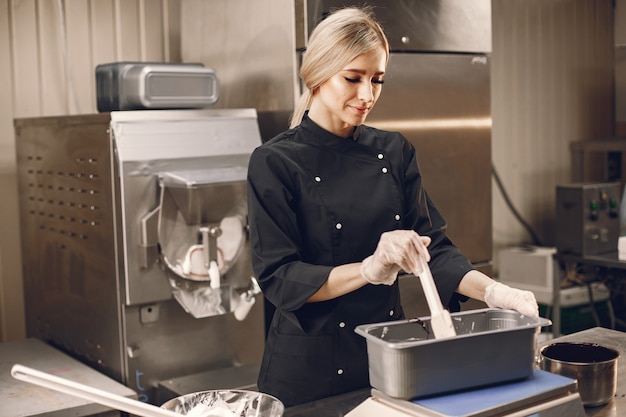 Woman making ice cream at commercial kitchen.