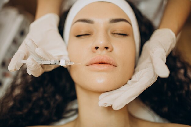 Woman making injections at cosmetologist