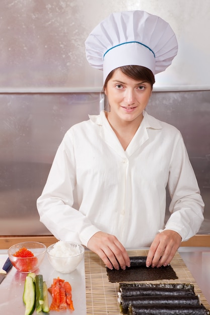 Free photo woman making  japanese sushi rolls