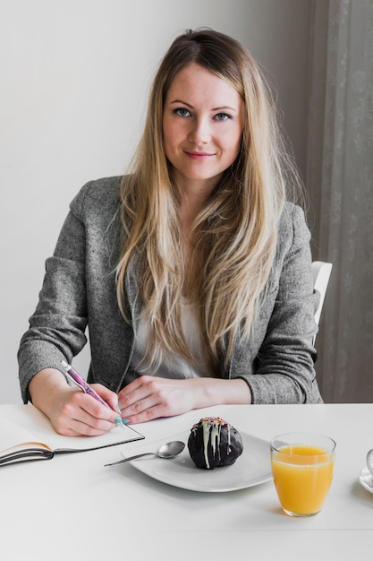 Woman making notes during breakfast