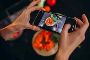 Foto gratuita donna che fa foto di un pasto sul suo telefono