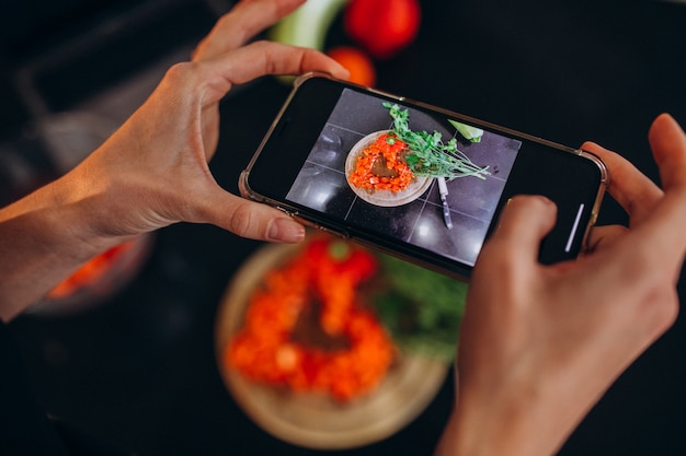 Женщина делает фото еды на свой телефон