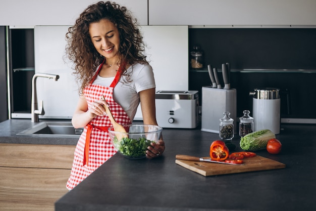 Женщина готовит салат на кухне