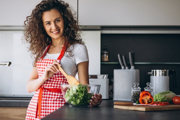 Foto gratuita donna che produce insalata in cucina