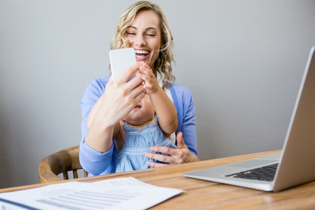 Woman making a selfie with a baby