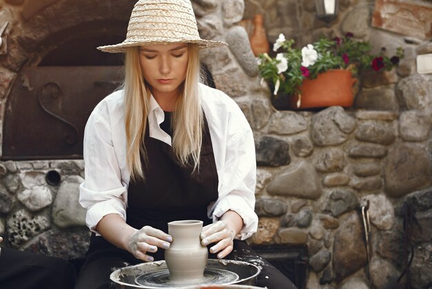 Woman making a vase with clay