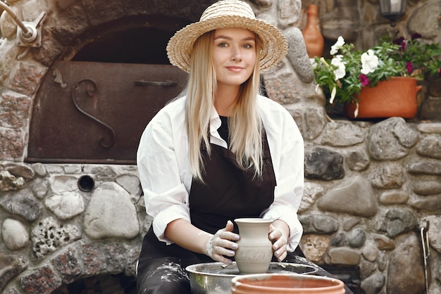 Woman making a vase with clay