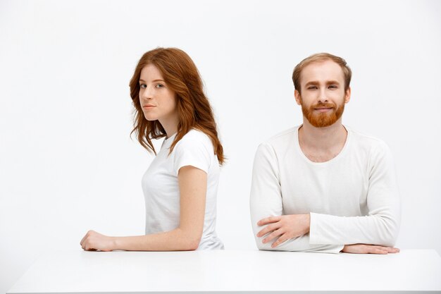 Woman and man both redhead sit at table