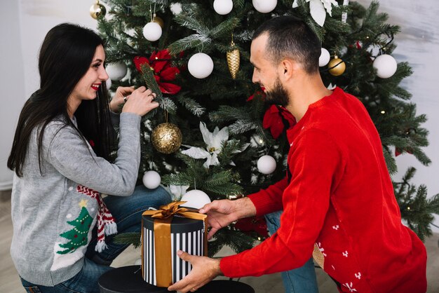 Woman and man decorating Christmas tree