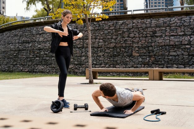 Woman and man exercising together outdoors
