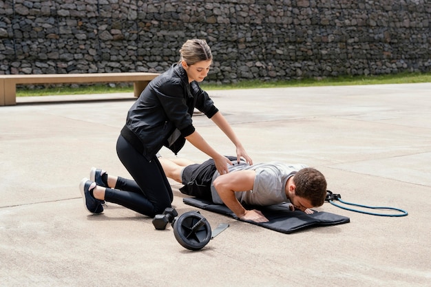 Woman and man exercising together outside