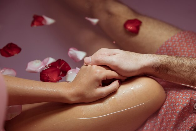 Woman and man holding hands in spa tub with water