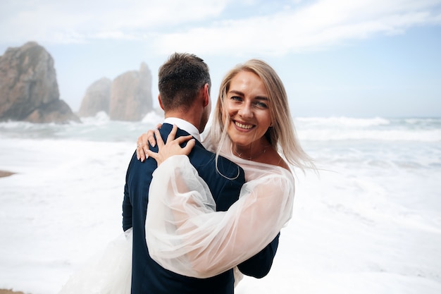 Woman and man hugging stand on the ocean beach