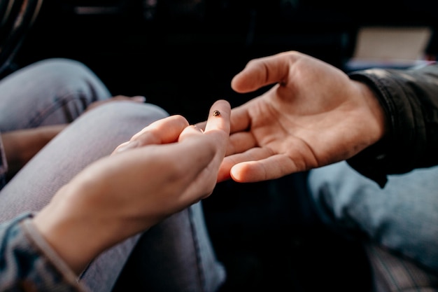 Woman and man looking at a small insect