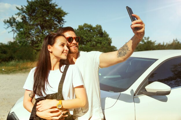 Woman and man making selfie in the forest and looks happy. Concept of relationship.