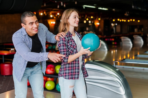 Woman and man playing bowling