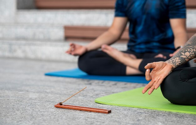 Woman and man practicing yoga on mat next to steps
