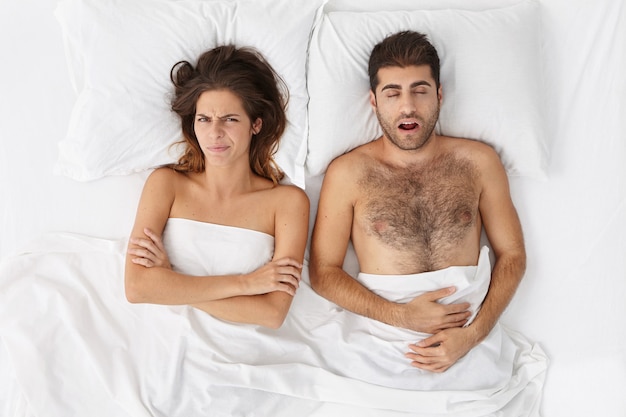 Free photo woman and man sitting in bed top view