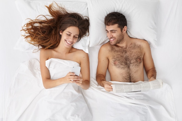 Woman and man sitting in bed top view