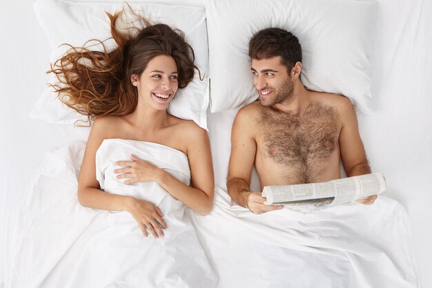 Женщина и мужчина, сидя в постели, вид сверху