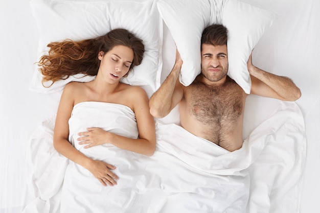 Woman and man sitting in bed top view