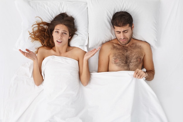 Free photo woman and man sitting in bed top view