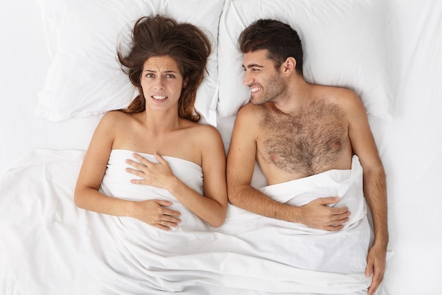 Woman and man sitting in bed top view