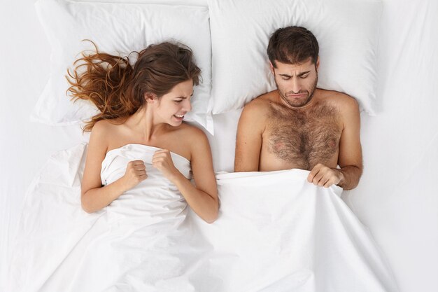 Woman and man sitting in bed top view