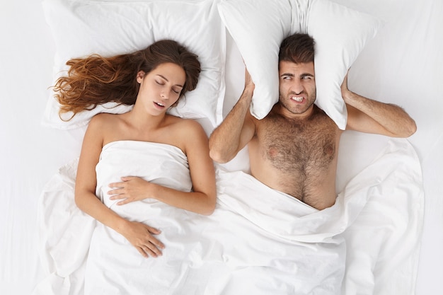 Woman and man sitting in bed top view